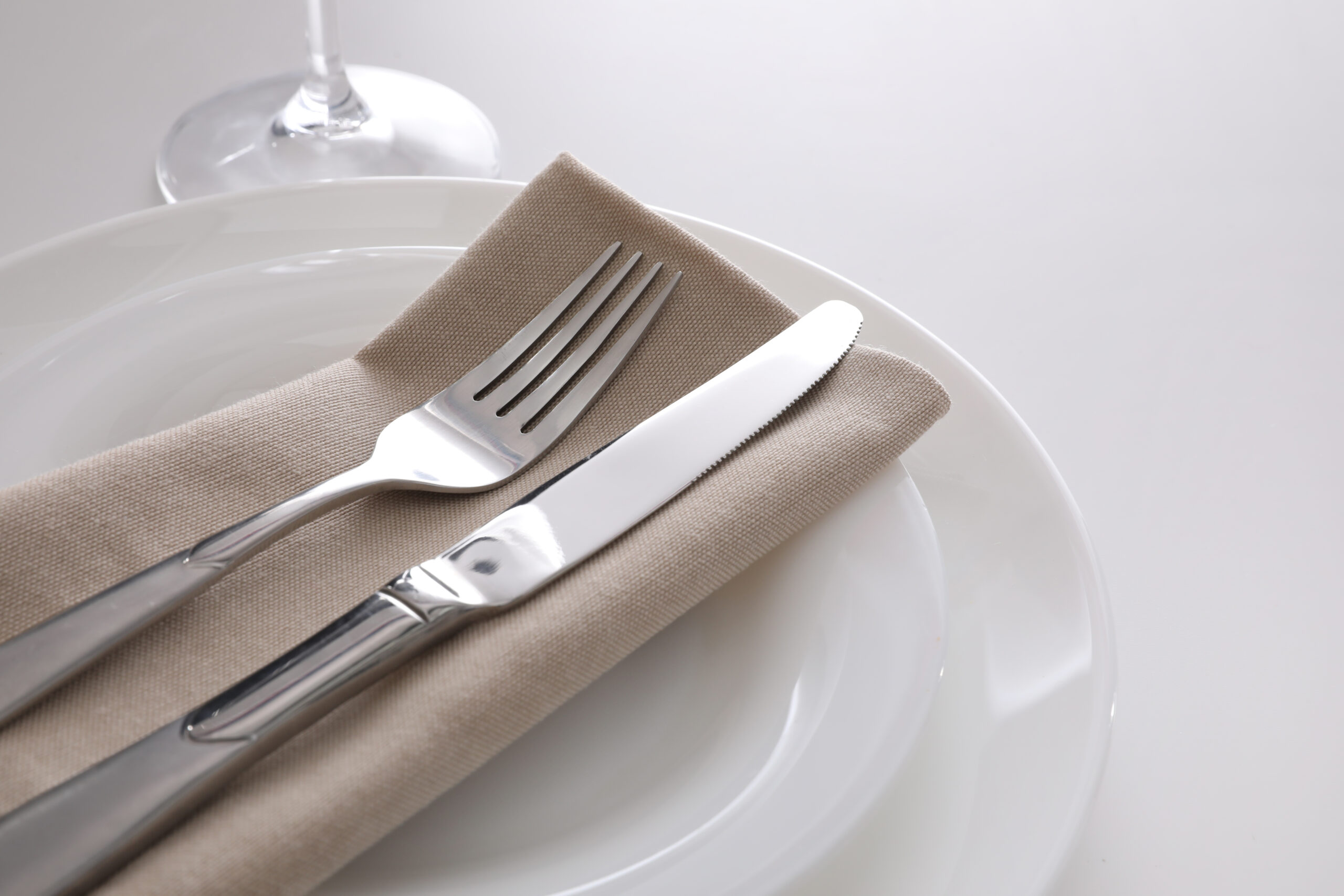 Elegant,cutlery,with,napkin,on,white,table,,closeup